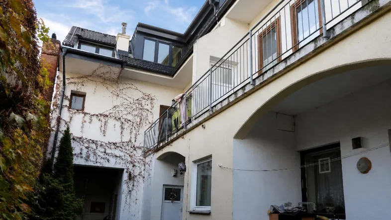 Ansicht der Gebäudefassade mit Balkonen und einem begrünten Innenhofbereich.