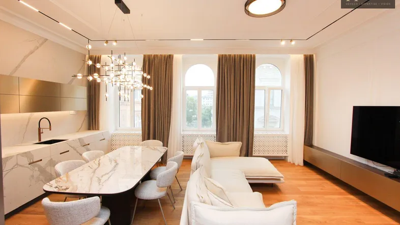 Moderner offener Wohn- und Essbereich mit integrierter Küche und Holzboden.