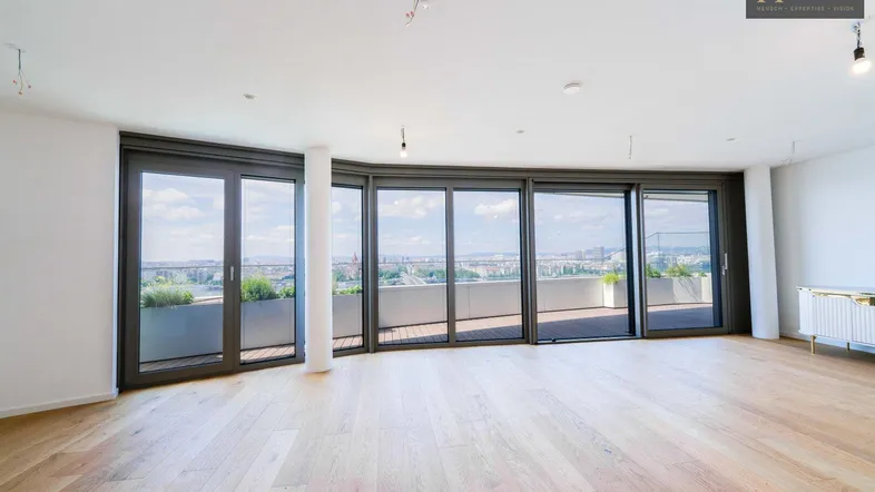 Helles, geräumiges Wohnzimmer mit Holzboden und großen Fenstern mit weitem Stadtblick.