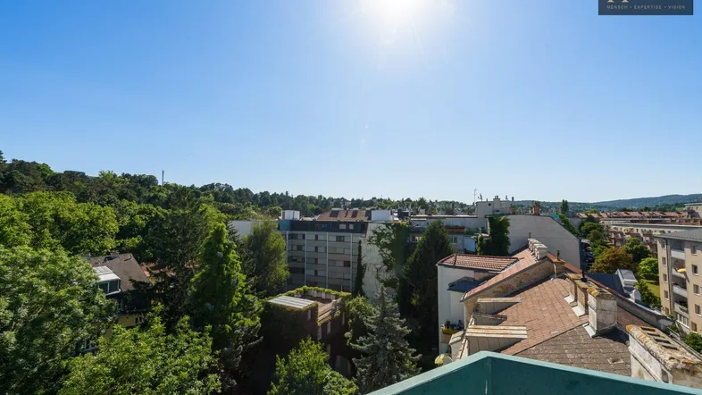 Panoramablick über die Stadt mit viel Grün und sonnigem Himmel von einer erhöhten Position.
