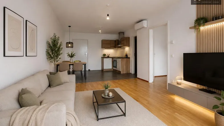 Helles, offenes Wohn-Esszimmer mit integrierter Küche, Parkettboden und moderner Einrichtung.