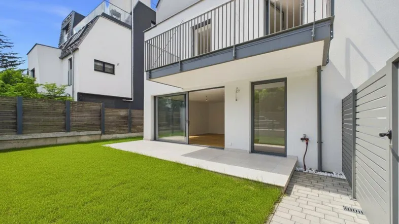 Blick auf die Terrasse und den gepflegten Gartenbereich eines modernen Reihenhauses.