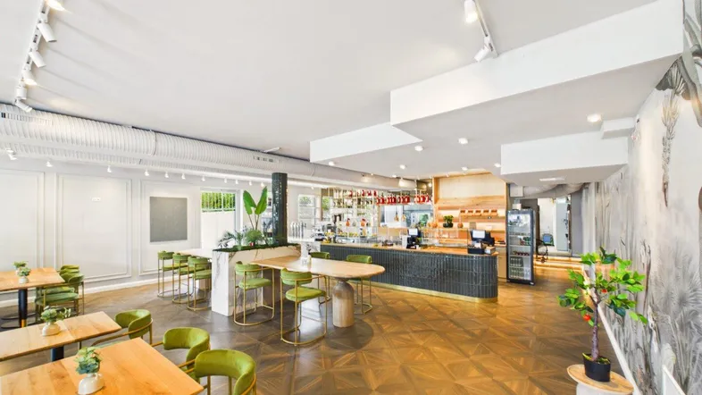 Geräumiger Restaurantbereich mit modernen Möbeln, Holzboden und einer gut ausgestatteten Bar.