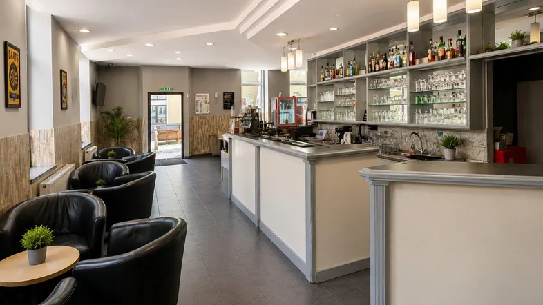 Bar- und Loungebereich mit dunklen Ledersesseln und einer gut ausgestatteten Theke.