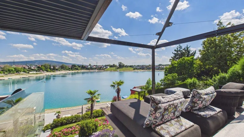 Geräumige Terrasse mit bequemen Loungemöbeln und atemberaubendem Blick auf den See und die umliegende Landschaft.