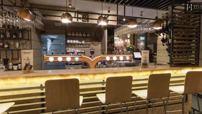 Moderne Bar mit beleuchteter Theke, Bierhähnen und Hockern, ideal für gesellige Abende in stilvollem Ambiente.