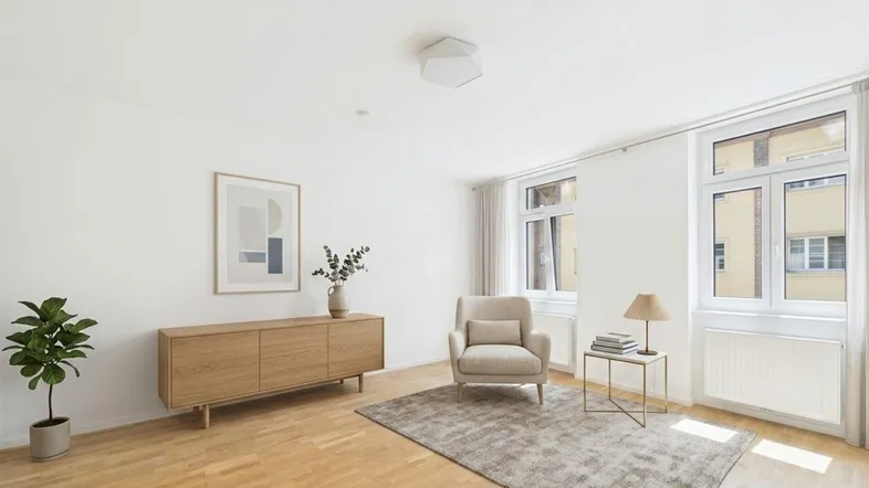 Helles Wohnzimmer mit modernem Holzsideboard, beigem Sessel und Parkettboden, lichtdurchflutet durch große Fenster.