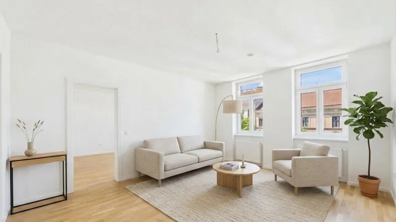 Helles Wohnzimmer mit modernem Sofa, Sessel und Holzboden, bietet eine einladende Atmosphäre.