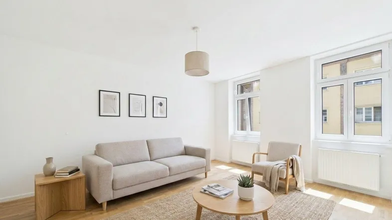 Helles Wohnzimmer mit modernem Sofa, Couchtisch und großen Fenstern für viel Tageslicht.