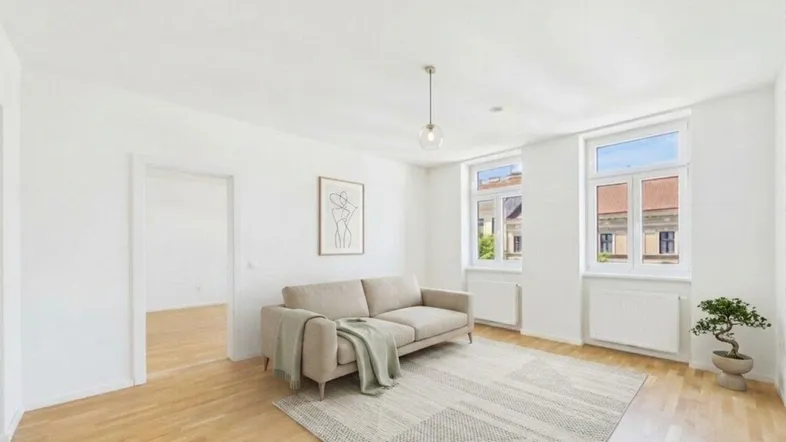 Helles Wohnzimmer mit modernem Sofa, Holzboden und Blick auf die umliegenden Gebäude.