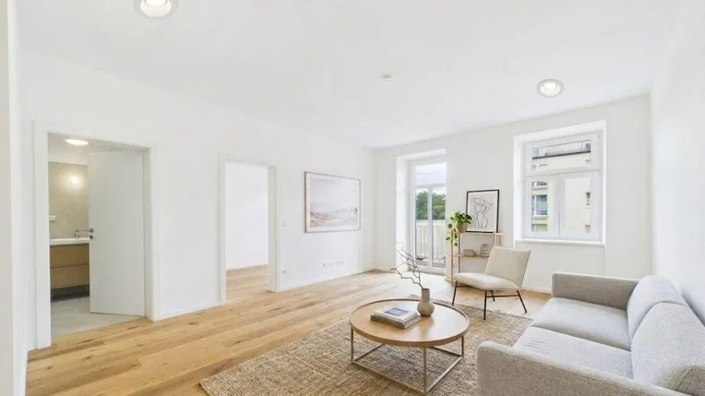 Helles Wohnzimmer mit Holzboden, moderner Einrichtung und Zugang zu einem französischen Balkon.