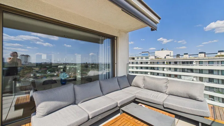 Geräumige Terrasse mit bequemen Lounge-Möbeln und weitem Blick über die Stadtlandschaft.