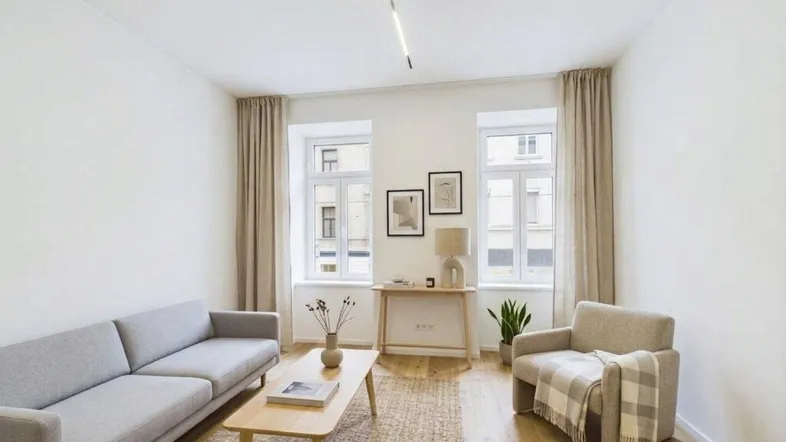 Helles Wohnzimmer mit modernem Design, Holzboden und großen Fenstern, die viel Tageslicht hereinlassen.
