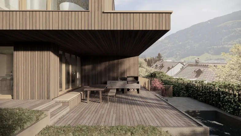 Große Holzterrasse mit Essbereich, Grillstation und kleinem Pool, umgeben von grüner Natur und Bergblick.