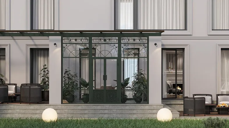 Elegante Gebäudefassade mit einer möblierten Terrasse und einem verglasten Wintergartenbereich.