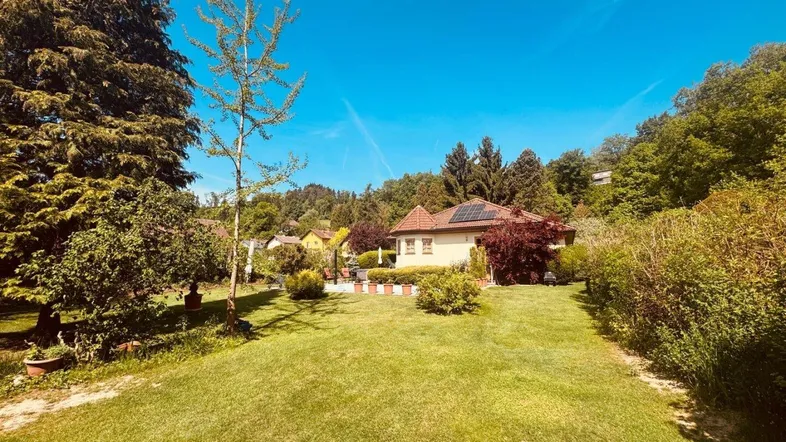 Weitläufiger Garten mit gepflegtem Rasen und Blick auf das charmante Einfamilienhaus.