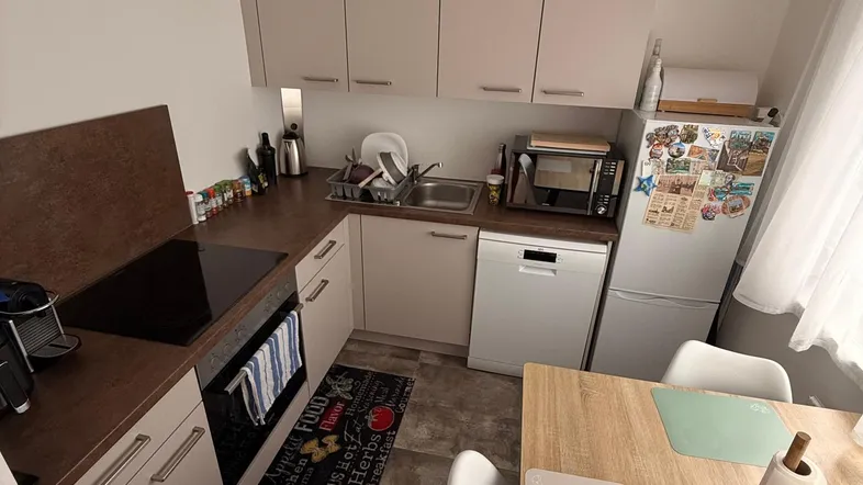Moderne Küche mit integrierten Geräten, Esstisch und Fliesenboden.