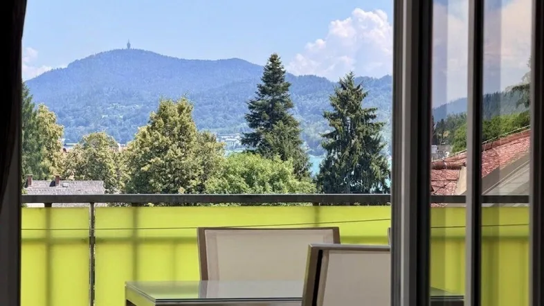 Balkon mit Sitzgelegenheiten und atemberaubendem Blick auf den See und die Berge.