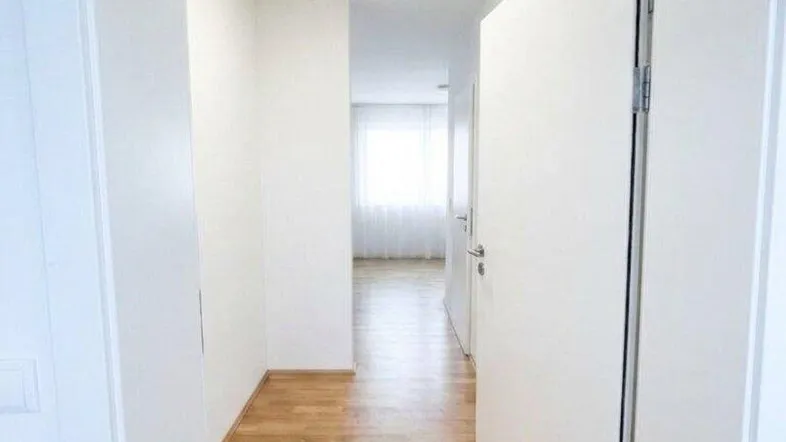 Heller Flur mit Holzparkettboden und Zugang zu weiteren Räumen in der Wohnung.