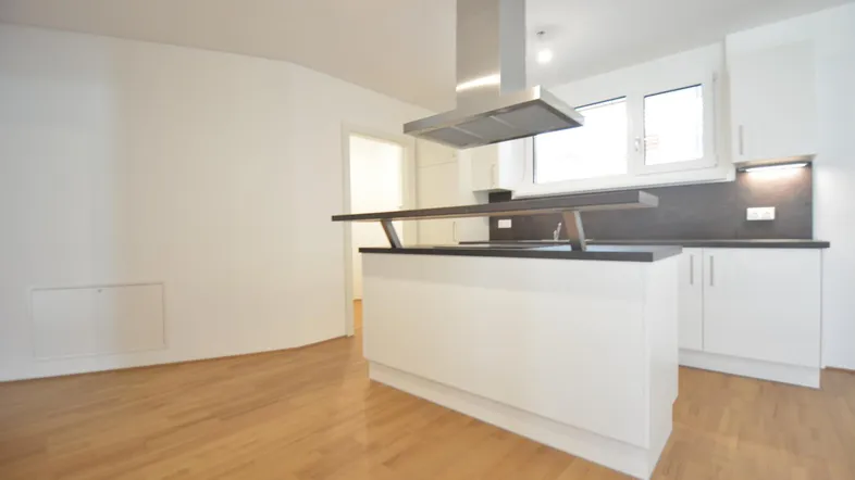Moderne Küche mit Kochinsel, Dunstabzugshaube und hellem Holzfußboden in offenem Wohnbereich.