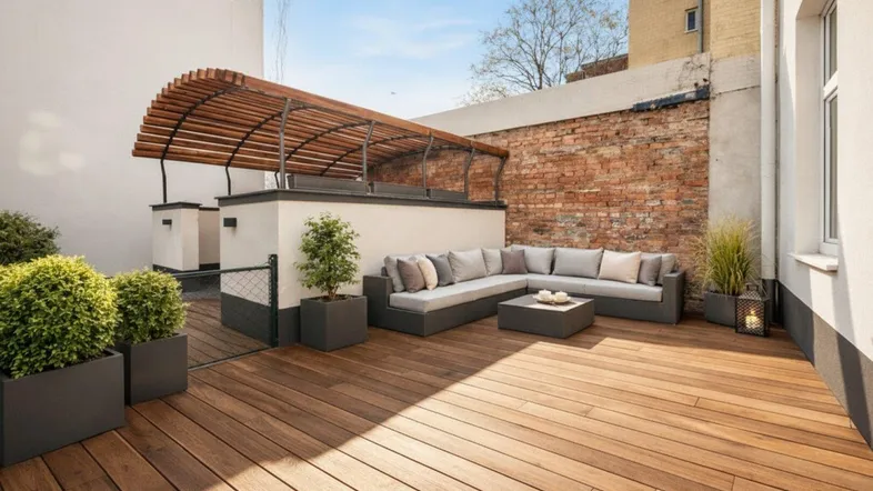Großzügige Terrasse mit Holzdeck, bequemen Lounge-Möbeln und einer Pergola für entspannte Stunden im Freien.