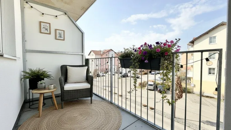 Gemütlicher Balkon mit Sitzgelegenheiten, Pflanzen und Blick auf die umliegenden Gebäude.