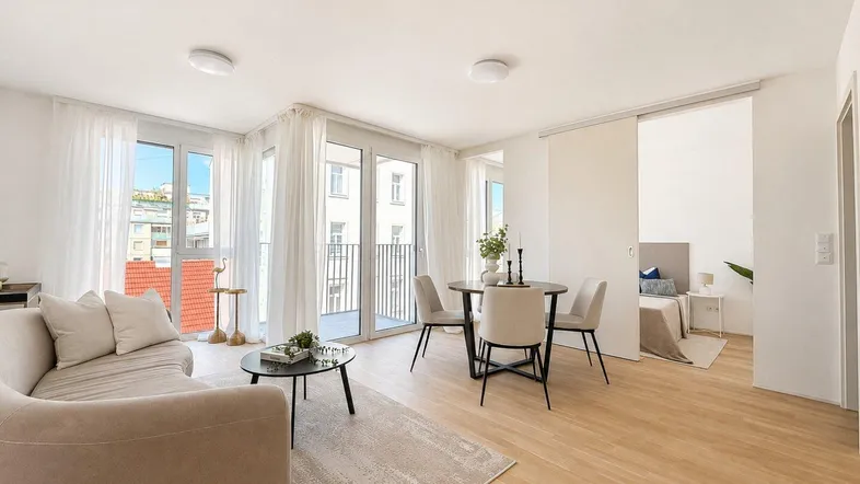 Helles Wohn- und Esszimmer mit modernem Sofa, Esstisch und Zugang zum Balkon.