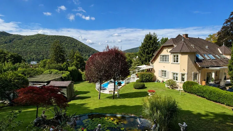 Großzügiger Garten mit Swimmingpool, Teich und weitem Blick auf die umliegende grüne Hügellandschaft.