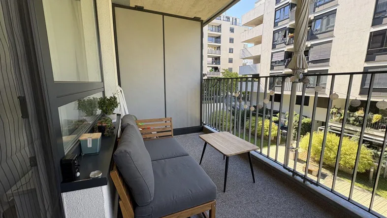 Gemütlicher Balkon mit Sitzgelegenheiten und Blick auf den Innenhof.