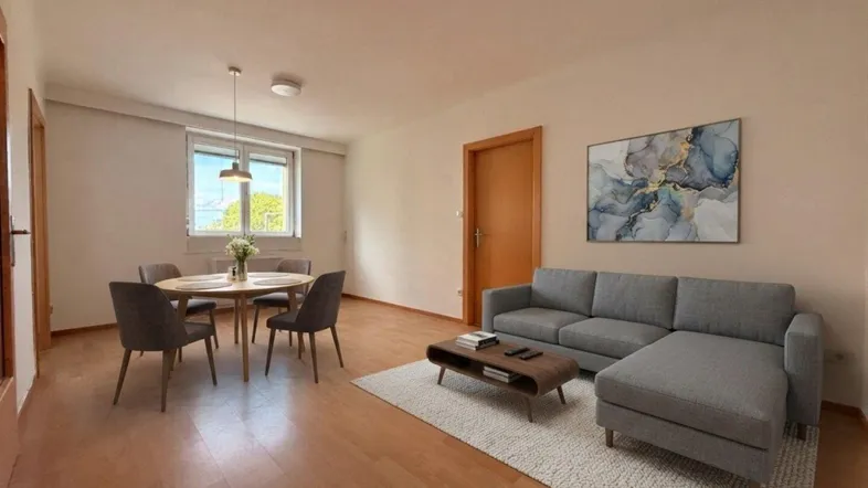 Helles Wohn- und Esszimmer mit Parkettboden, modernem Sofa und Esstisch am Fenster.