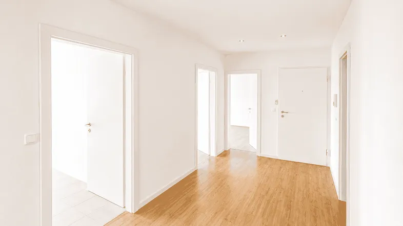 Heller Flur mit Laminatboden und Zugang zu mehreren Zimmern in einem gepflegten Zustand.