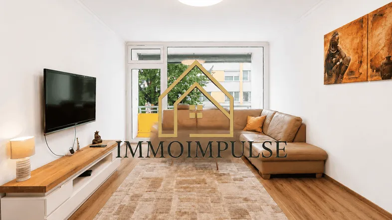 Helles Wohnzimmer mit beiger Ledercouch, Holzboden und Zugang zu einem Balkon.