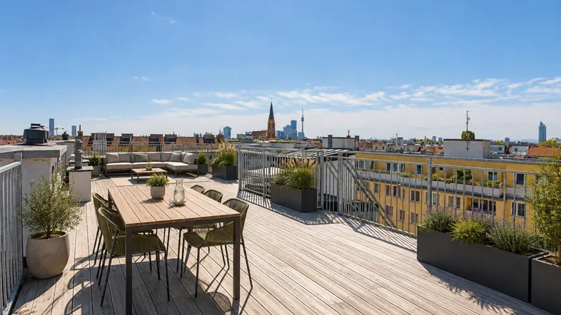 Große Dachterrasse mit Essbereich, Lounge-Möbeln und weitem Blick über die Stadt.