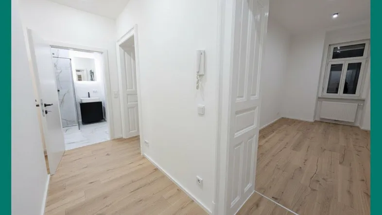 Heller Flur mit modernem Holzboden, der zu einem Badezimmer und weiteren Räumen führt.