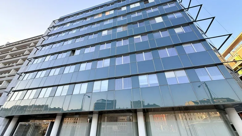 Modernes Bürogebäude mit Glasfassade und klaren Linien unter blauem Himmel, das eine zeitgemäße Architektur zeigt.