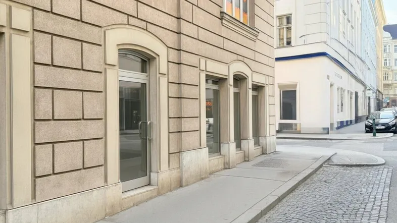 Ansicht der Gebäudefassade mit großen Fenstern und Eingangsbereichen auf Straßenniveau.