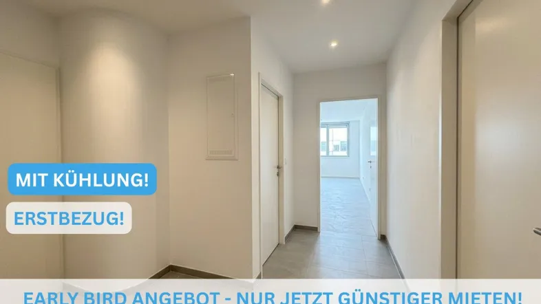 Heller Flur mit modernen Fliesen und weiß gestrichenen Wänden, der zu weiteren Räumen führt.