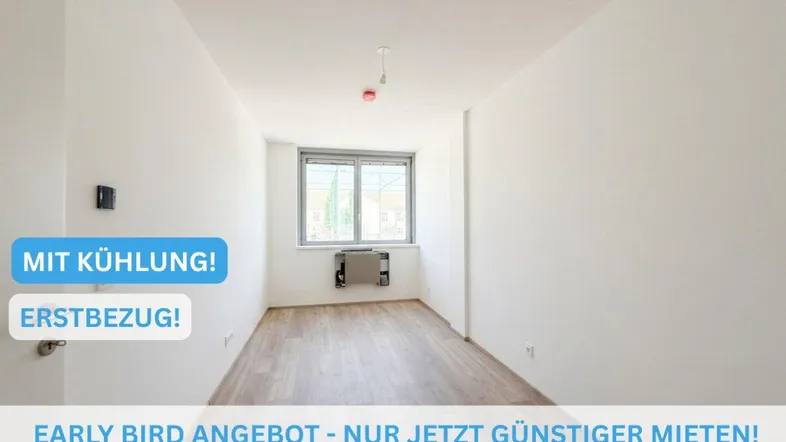 Helles, leeres Zimmer mit Fenster und Klimaanlage, bereit für den Erstbezug.