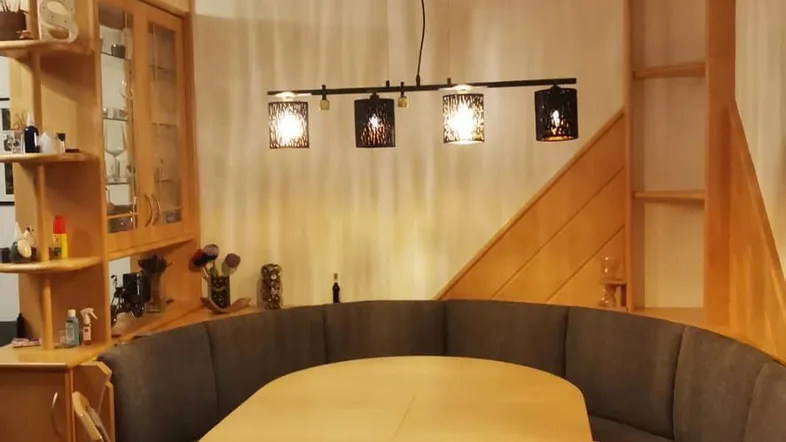 Gemütlicher Essbereich mit Holzelementen, Eckbank und Pendelleuchte, ideal für Familienmahlzeiten.