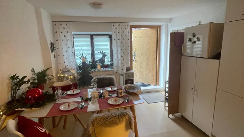 Gemütlicher Essbereich mit Holzboden und festlicher Dekoration, angrenzend an den Eingangsbereich.