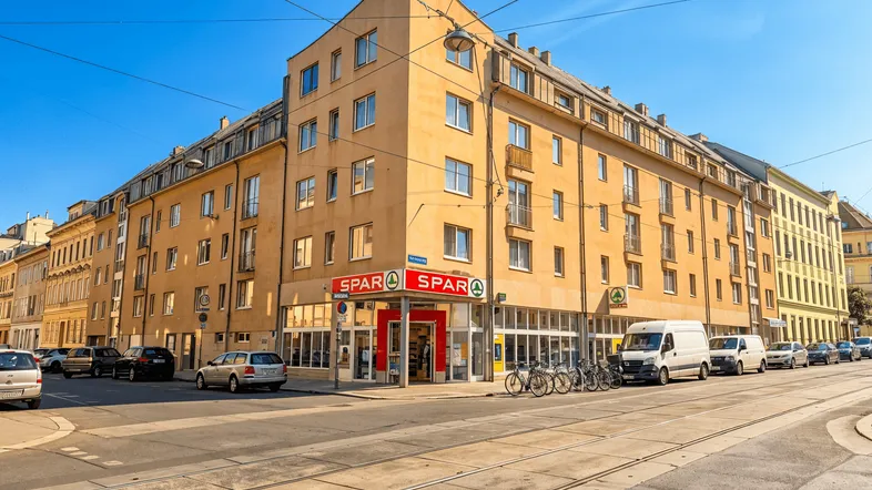 Gebäude an einer Straßenecke mit einem Supermarkt im Erdgeschoss und Wohnungen darüber.