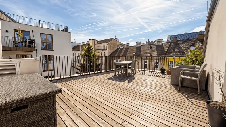 Große Dachterrasse mit Holzbelag und Gartenmöbeln, ideal für entspannte Stunden im Freien.