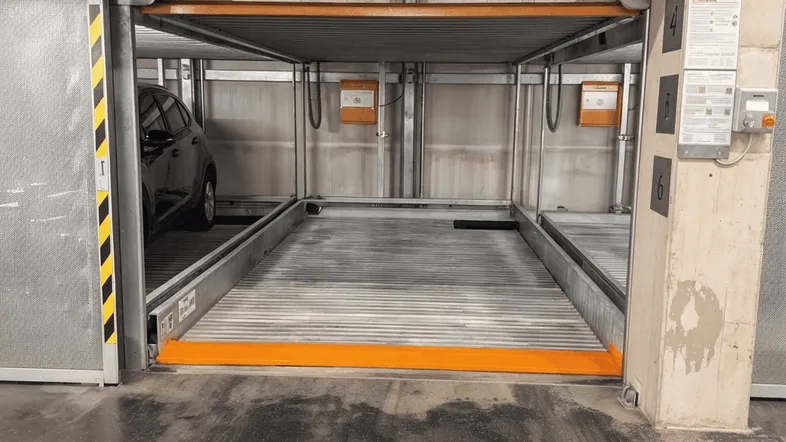 Automatisches Parksystem in einer Tiefgarage mit Betonwänden und einem geparkten Auto.