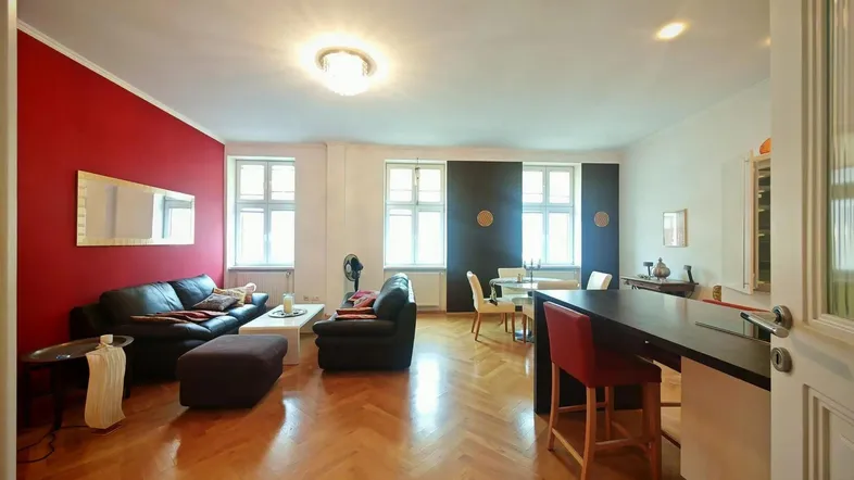 Helles und geräumiges Wohn-Esszimmer mit offener Küchenzeile und Fischgrätparkett.