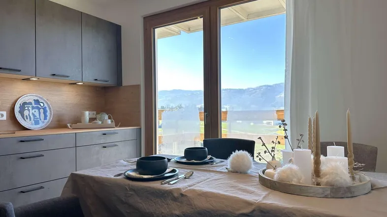 Moderner Essbereich mit integrierter Küche und großem Fenster mit Bergblick.