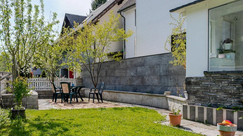 Gemütliche Terrasse mit Rasenfläche und Gartenmöbeln, ideal für entspannte Stunden im Freien.
