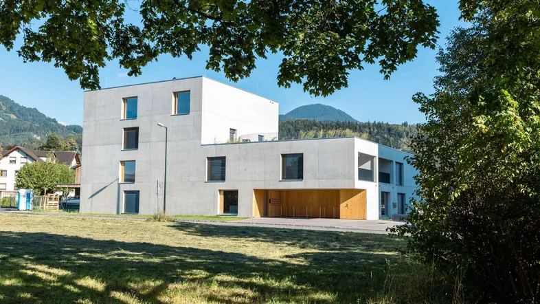 Modernes Wohngebäude mit klarer Architektur und Blick auf die umliegende Natur und Berge.