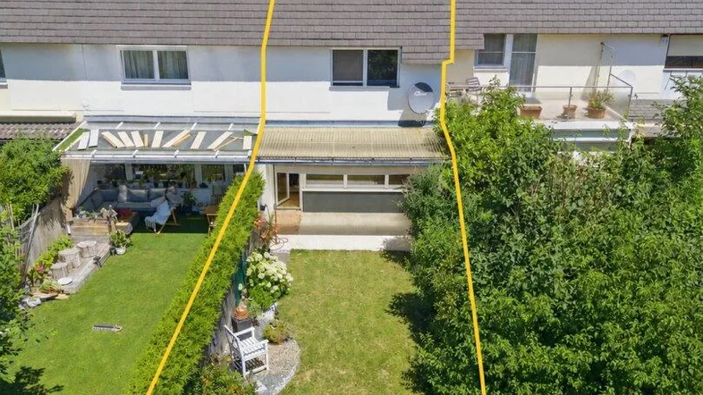 Luftaufnahme eines Reihenhauses mit Garten und Grundstücksgrenzen, umgeben von Bäumen.