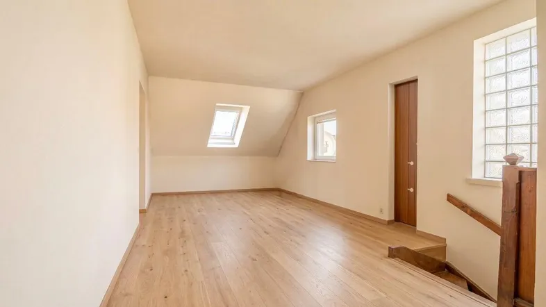 Renovierter Dachbodenbereich mit Holzboden, Dachfenstern und viel natürlichem Licht.