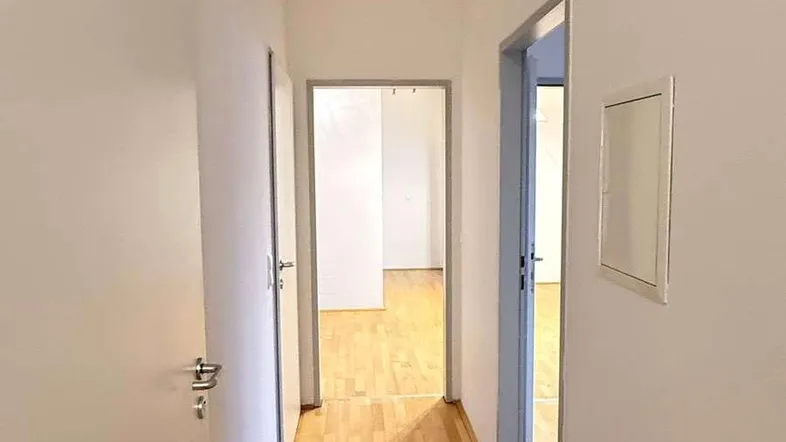 Heller Flur mit Parkettboden und Zugang zu verschiedenen Zimmern in der Wohnung.